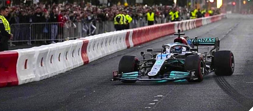 An F1 car racing around a corner protected with TrafFix Water Walls.